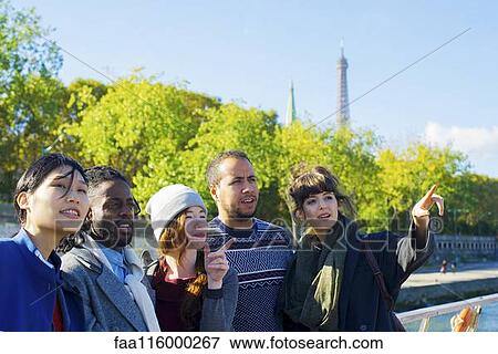 Stock Photo - Friends standing together in boat. Fotosearch