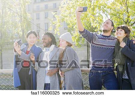 Stock Photography - Friends taking selfie in boat. Fotosearch
