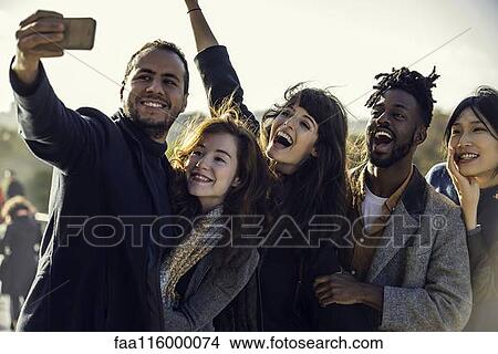 Friends taking selfie with smart phone View Large Photo Image Picture - Friends taking selfie with smart phone. Fotosearch