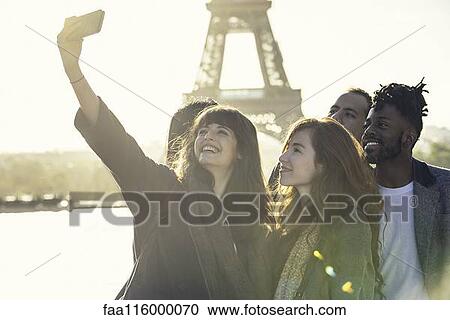 Stock Image - Friends taking selfie with smart phone. Fotosearch