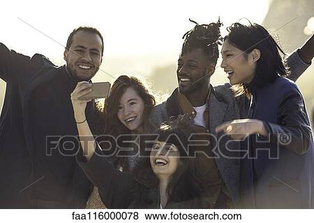 Friends taking selfie with smart phone View Large Photo Image Stock Photo - Friends taking selfie with smart phone. Fotosearch