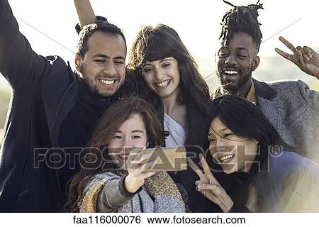 Friends taking selfie with smart phone View Large Photo Image Stock Photograph - Friends taking selfie with smart phone. Fotosearch