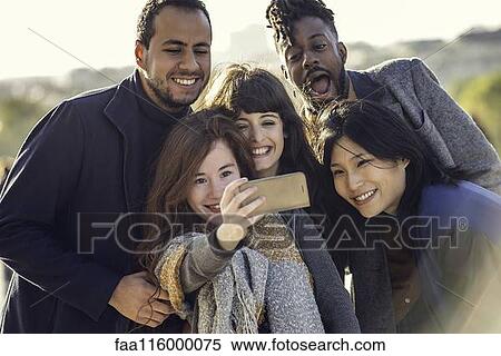 Friends taking selfie with smart phone View Large Photo Image Stock Photography - Friends taking selfie with smart phone. Fotosearch