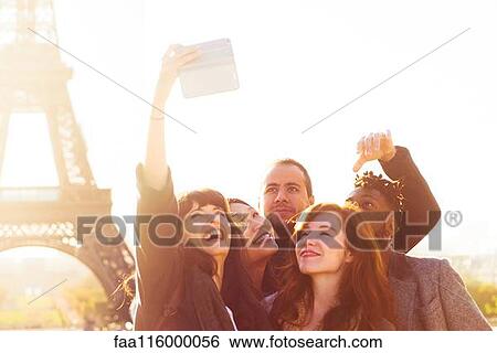 Stock Photograph - Friends taking selfie with smartphone. Fotosearch