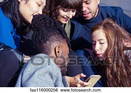 Stock Photo - Friends using smartphone. Fotosearch