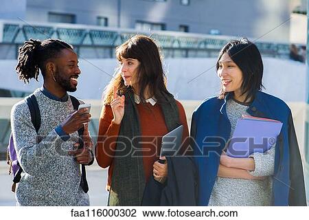 Friends walking together and using smartphone View Large Photo Image Stock Image - Friends walking together and using smartphone. Fotosearch