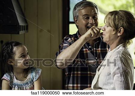 Girl with her grandparents in kitchen View Large Photo Image Stock Image - Girl with her grandparents in kitchen. Fotosearch