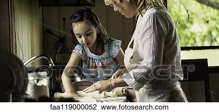 Granddaughter and grandmother preparing food View Large Photo Image Stock Image - Granddaughter and grandmother preparing food. Fotosearch