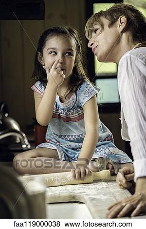 Stock Photo - Granddaughter and grandmother preparing food. Fotosearch
