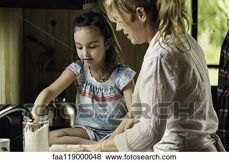Granddaughter and grandmother preparing food View Large Photo Image Stock Photo - Granddaughter and grandmother preparing food. Fotosearch