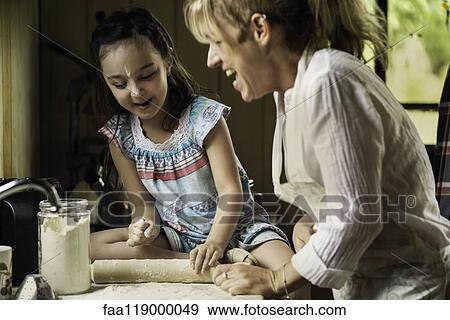 Granddaughter and grandmother preparing food View Large Photo Image Stock Photo - Granddaughter and grandmother preparing food. Fotosearch
