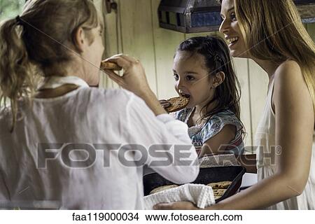 Grandmother and granddaughter having cookies in kitchen View Large Photo Image Picture - Grandmother and granddaughter having cookies in kitchen. Fotosearch