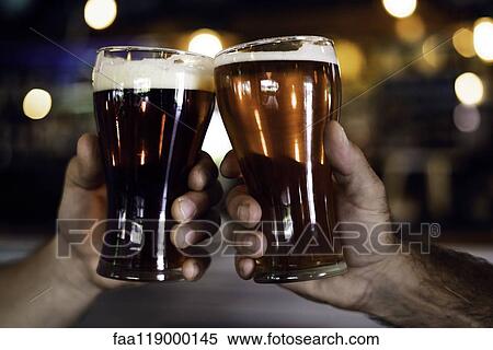 Hands toasting beer glasses View Large Photo Image Stock Photography - Hands toasting beer glasses. Fotosearch