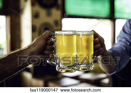 Hands toasting beer mugs View Large Photo Image Stock Photo - Hands toasting beer mugs. Fotosearch