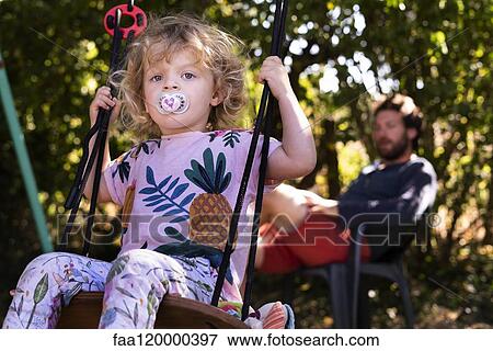 Little girl swinging on swing View Large Photo Image Stock Photo - Little girl swinging on swing. Fotosearch