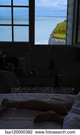 Stock Image - Low section of woman sleeping on bed. Fotosearch