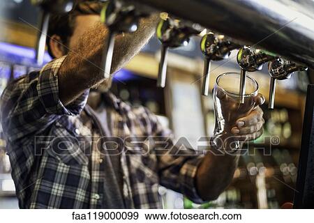 Man drawing beer from tap View Large Photo Image Stock Photo - Man drawing beer from tap. Fotosearch
