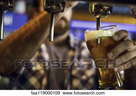 Stock Photo - Man drawing beer from tap. Fotosearch