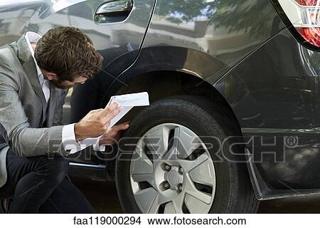 Man examining car View Large Photo Image Picture - Man examining car. Fotosearch