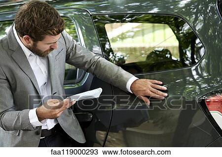 Man examining car View Large Photo Image Stock Image - Man examining car. Fotosearch