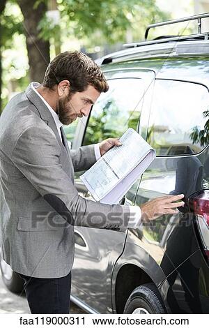Man examining car View Large Photo Image Stock Image - Man examining car. Fotosearch
