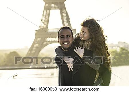 Stock Image - Man giving piggyback ride to his girlfriend. Fotosearch