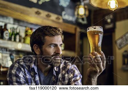 Man looking at beer glass View Large Photo Image Stock Image - Man looking at beer glass. Fotosearch