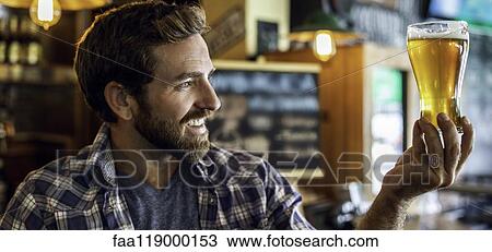Man looking at beer glass View Large Photo Image Stock Image - Man looking at beer glass. Fotosearch