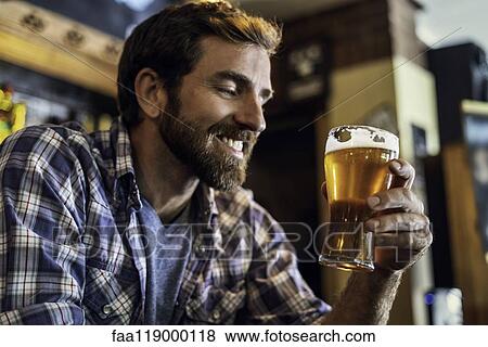 Man looking at beer glass View Large Photo Image Stock Photo - Man looking at beer glass. Fotosearch