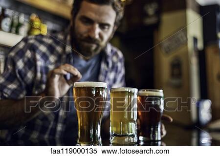 Man looking at beer glass View Large Photo Image Stock Photography - Man looking at beer glass. Fotosearch