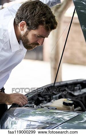 Stock Photo - Man looking at car engine. Fotosearch