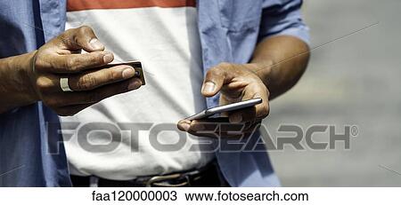 Stock Image - Man making online payment with credit card. Fotosearch