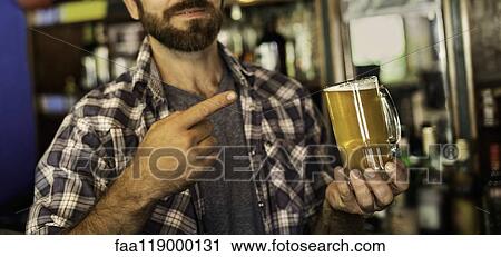 Man pointing at beer mug View Large Photo Image Stock Image - Man pointing at beer mug. Fotosearch