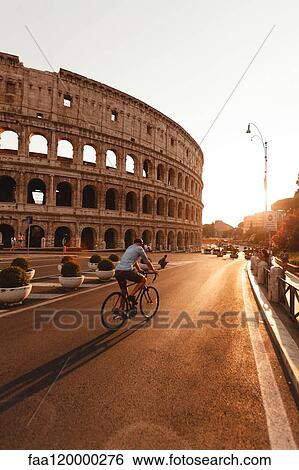 Man riding bicycle by Colosseum View Large Photo Image Stock Photograph - Man riding bicycle by Colosseum. Fotosearch