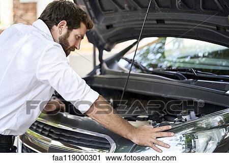 Man standing by car View Large Photo Image Stock Image - Man standing by car. Fotosearch
