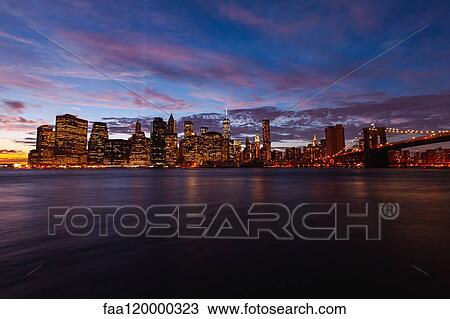 Manhattan skyline and Brooklyn Bridge at dusk View Large Photo Image Stock Image - Manhattan skyline and Brooklyn Bridge at dusk. Fotosearch