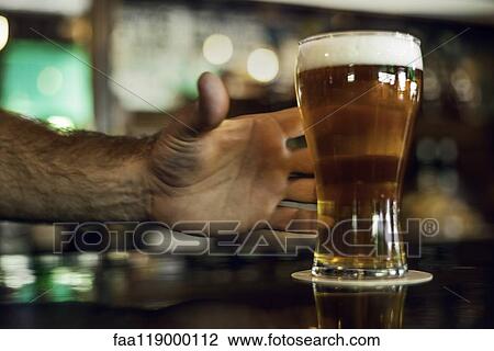 Man's hand holding beer glass View Large Photo Image Stock Image - Man's hand holding beer glass. Fotosearch