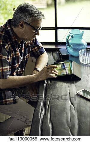 Mature man using digital tablet View Large Photo Image Stock Photograph - Mature man using digital tablet. Fotosearch