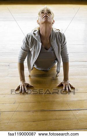 Stock Photo - Mature woman exercising at home. Fotosearch