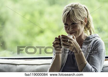 Mature woman having coffee at home View Large Photo Image Picture - Mature woman having coffee at home. Fotosearch