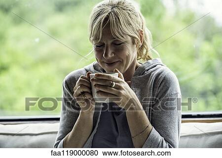 Stock Image - Mature woman having coffee. Fotosearch
