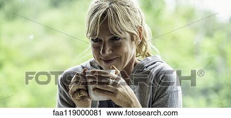 Stock Image - Mature woman having coffee. Fotosearch
