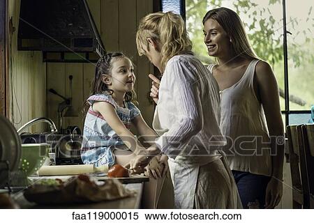 Stock Photography - Mature woman talking her granddaughter in kitchen. Fotosearch