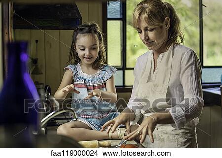 Mature woman teaching her granddaughter in kitchen View Large Photo Image Picture - Mature woman teaching her granddaughter in kitchen. Fotosearch