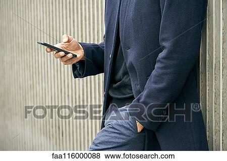 Mid section of businessman using smartphone View Large Photo Image Stock Photo - Mid section of businessman using smartphone. Fotosearch