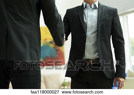 Mid section of businessmen shaking hands in office lobby View Large Photo Image Stock Photo - Mid section of businessmen shaking hands in office lobby. Fotosearch