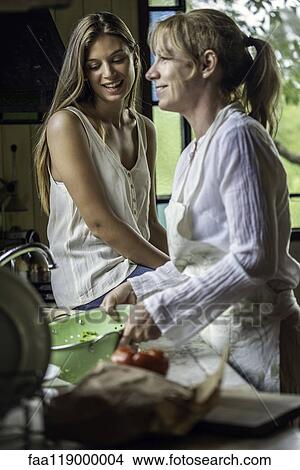 Mother and daughter preparing food in kitchen View Large Photo Image Picture - Mother and daughter preparing food in kitchen. Fotosearch