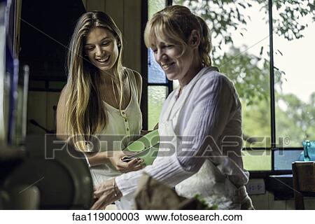 Mother and daughter preparing food in kitchen View Large Photo Image Stock Image - Mother and daughter preparing food in kitchen. Fotosearch