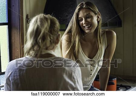 Stock Photo - Mother and daughter talking in kitchen. Fotosearch