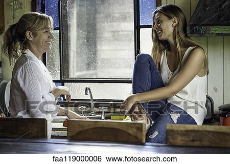 Stock Photograph - Mother and daughter talking in kitchen. Fotosearch